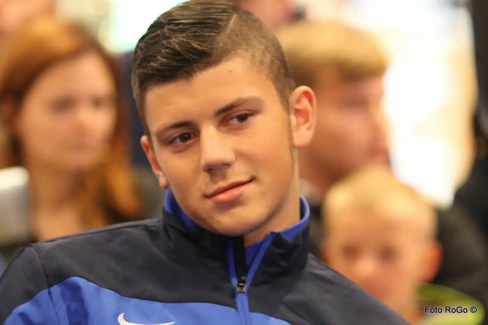 Porträt von Dawid Kownacki in einer blau-schwarzen Sportjacke.